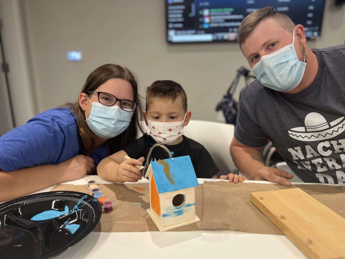 Image from Moments of Joy - Family picture of a kid painting a miniature house