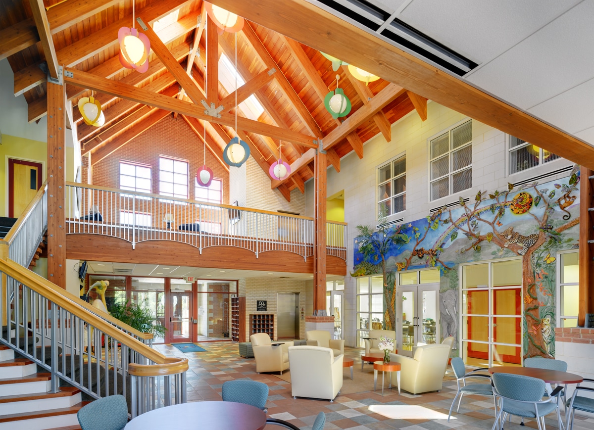 Lobby with hanging lights, animal scene art wall and main staircase in Cincinnati's Ronald McDonald House