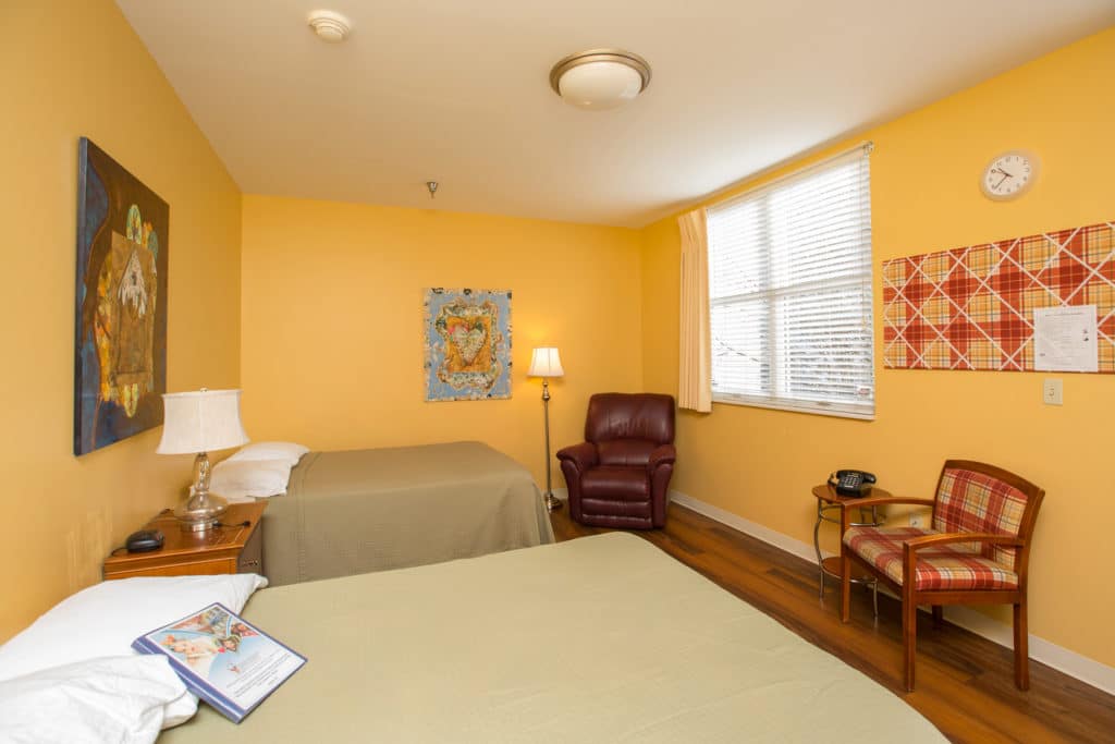 Two beds and two chairs inside a room