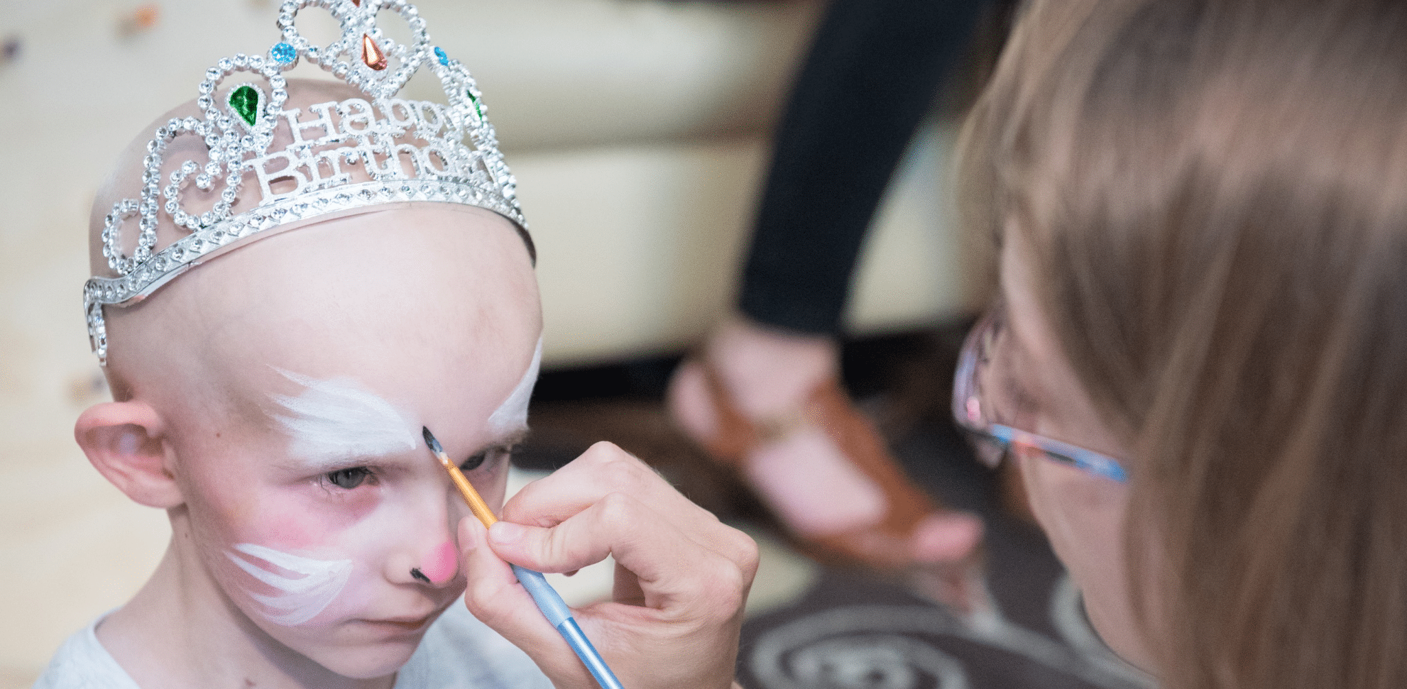 Young girl with no hair having face painted