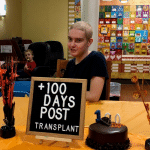 Teenage boy with cake and celebration sign