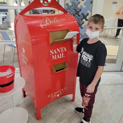 Child mailing a letter to Santa Claus