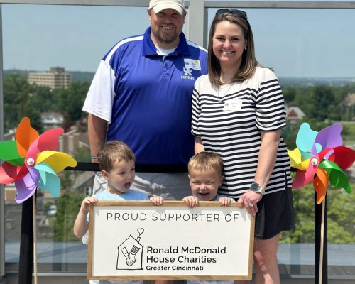 A family holding a sign, "Proud Supporter Of Ronald McDonald House Charities Greater Cincinnati"