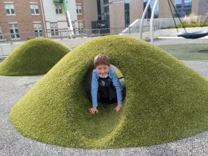 A child playing in a playground tunnel