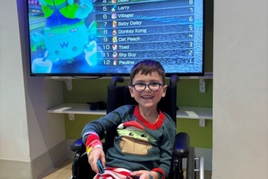 Boy smiling in front of gaming results screen.