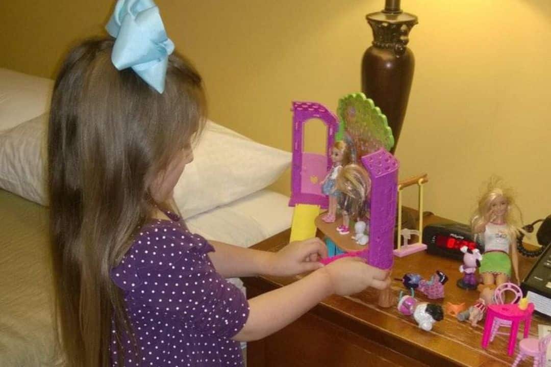 Young Ava playing with her new toy on a nightstand.